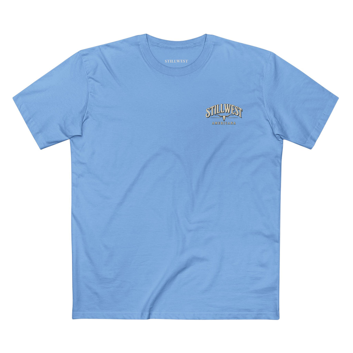 A light blue crewneck t-shirt with a small gold and white 'Still West' logo printed on the left chest, displayed flat against a solid white background.