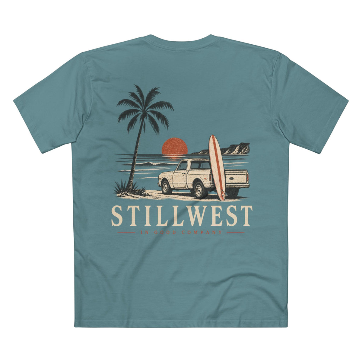 A teal blue short-sleeve t-shirt shown from the back, featuring a retro-style graphic of a beach scene with a palm tree, a cream pickup truck carrying a surfboard, a red-orange sun, and the text 'STILLWEST' in cream.